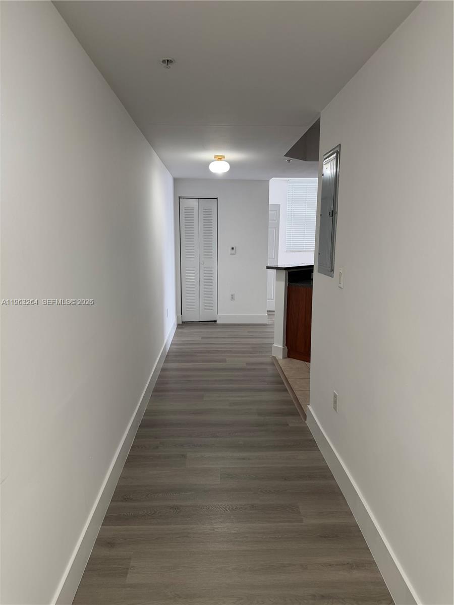 115 Southwest 11th Street, Unit 805 Miami, FL 33130 - Photo 2 of 13 a view of a hallway with wooden floor and a window