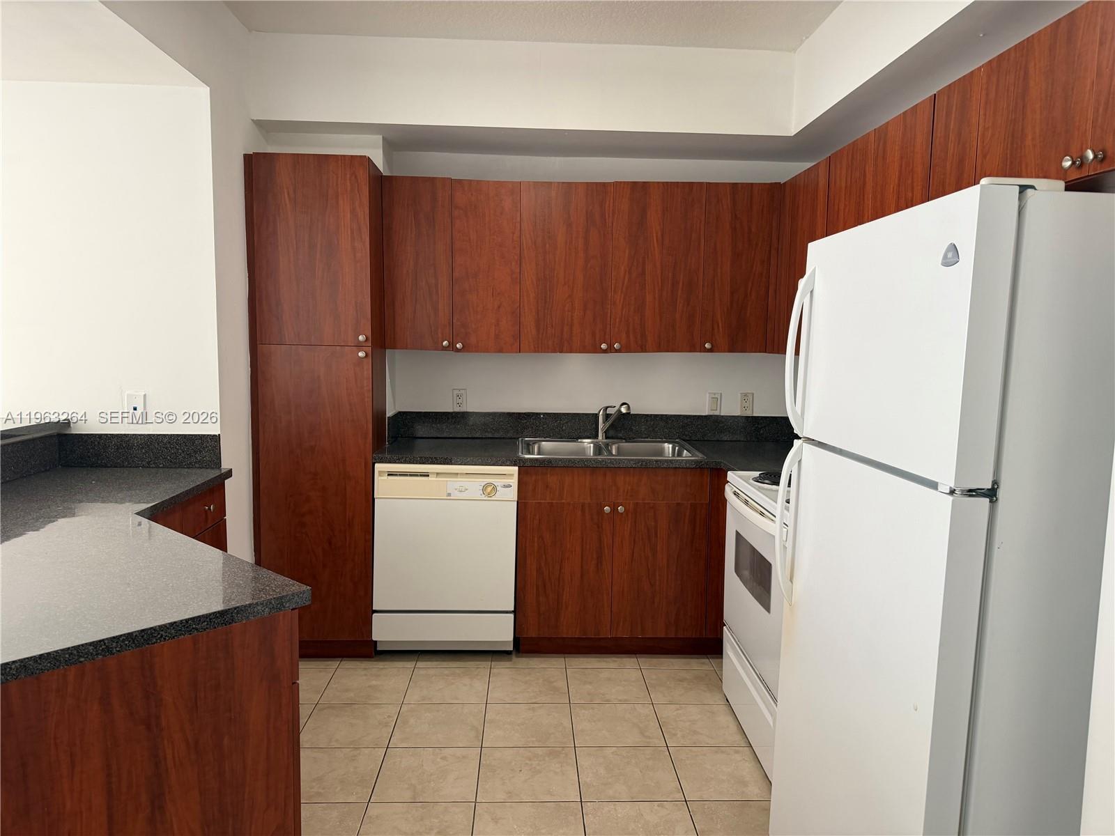 115 Southwest 11th Street, Unit 805 Miami, FL 33130 - Photo 3 of 13 a kitchen with a refrigerator sink stove and cabinets