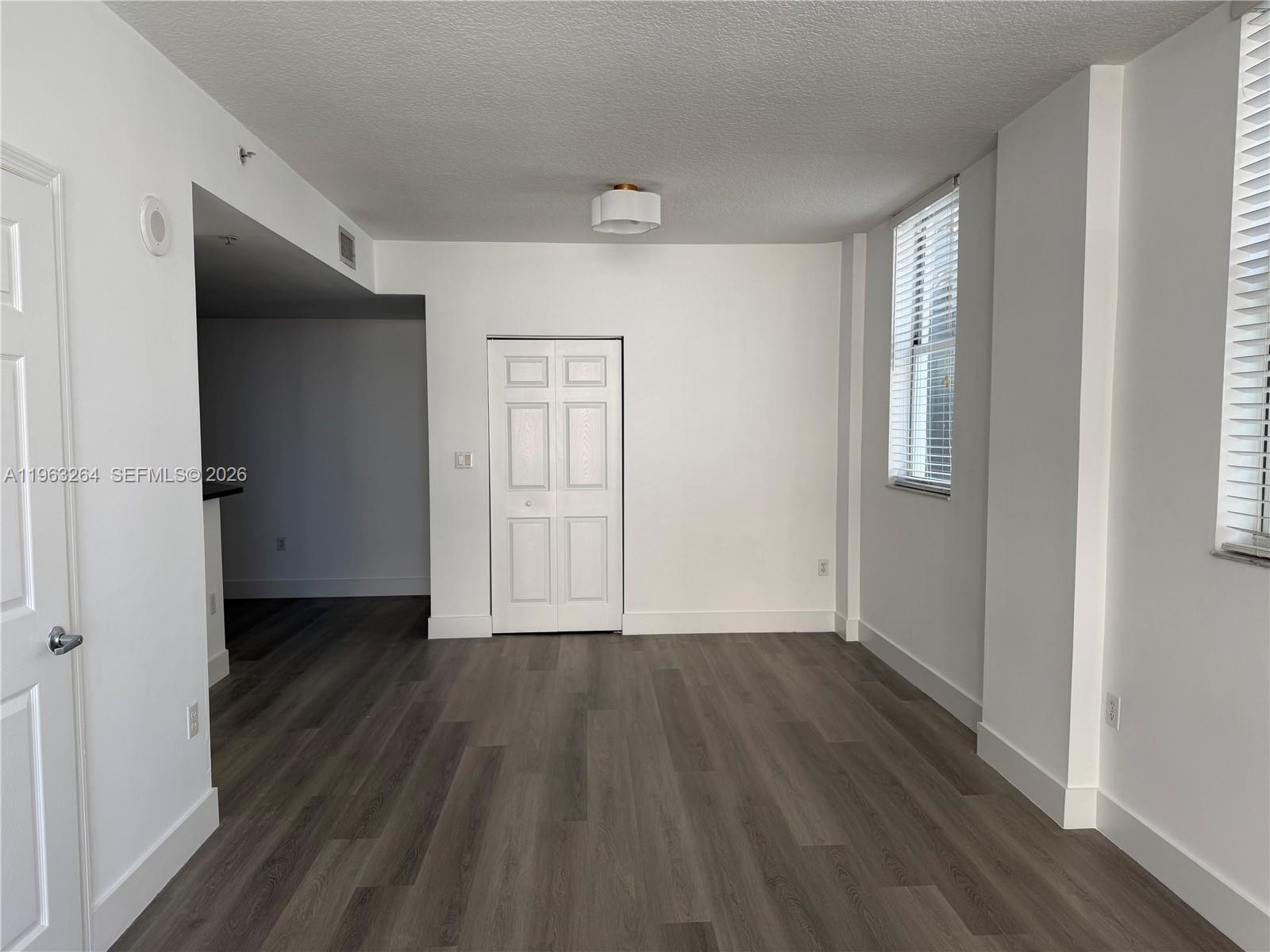115 Southwest 11th Street, Unit 805 Miami, FL 33130 - Photo 6 of 13 an empty room with wooden floor and a window