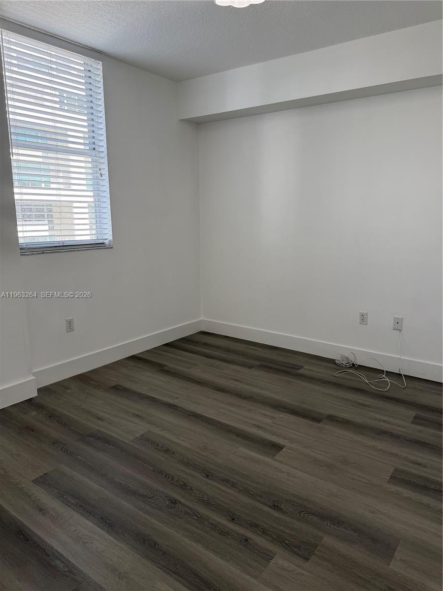 115 Southwest 11th Street, Unit 805 Miami, FL 33130 - Photo 8 of 13 a view of a small space with wooden floor and a window