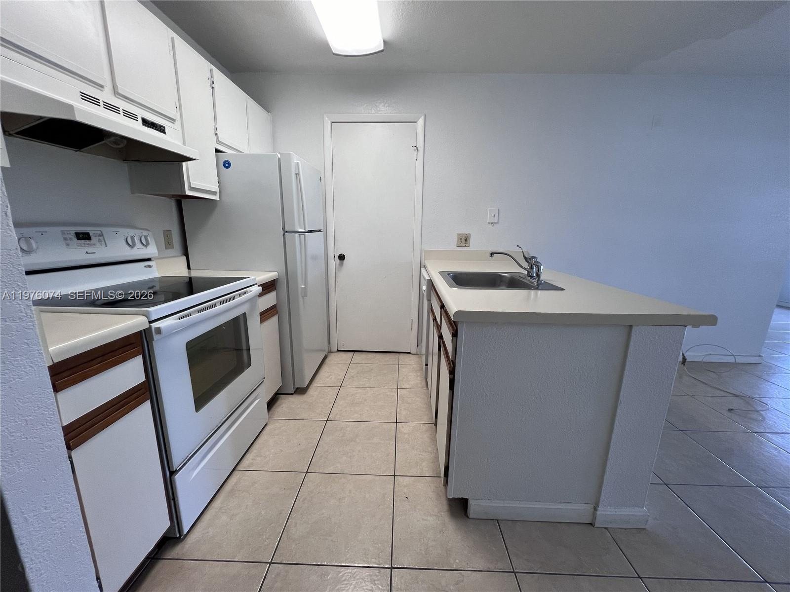 4221 West McNab Road, Unit 43 Pompano Beach, FL 33069 - Photo 8 of 23 a kitchen with a stove top oven and cabinets