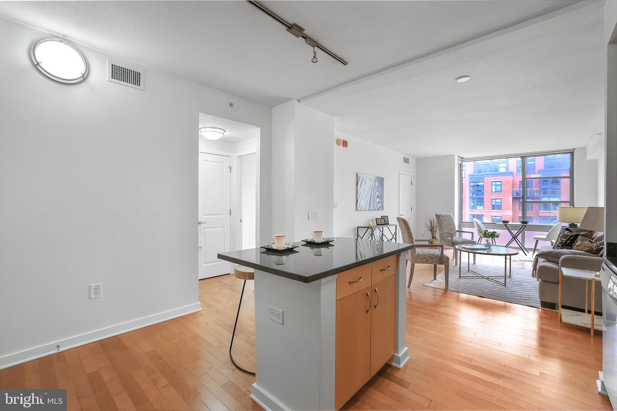 475 K Street Northwest, Unit 920 Washington, DC 20001 - Photo 4 of 25 a kitchen with stainless steel appliances granite countertop a sink and a stove with wooden floor