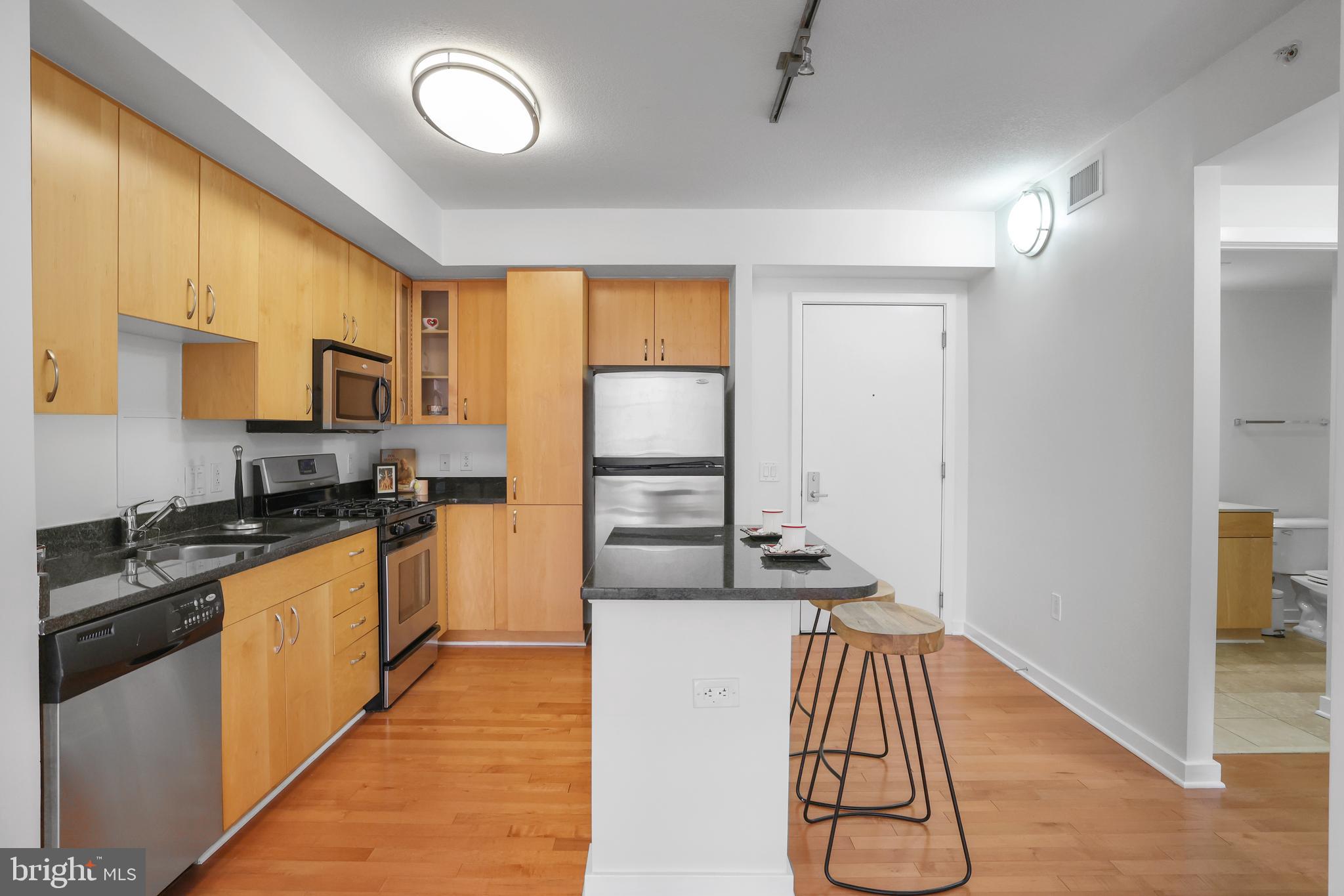 475 K Street Northwest, Unit 920 Washington, DC 20001 - Photo 6 of 25 a kitchen with granite countertop stainless steel appliances and wooden cabinets