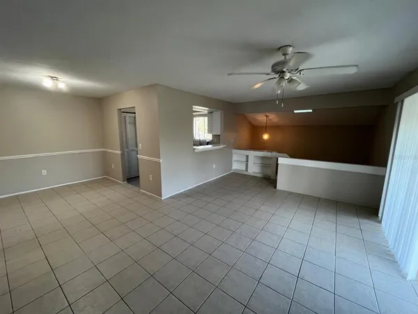 a view of an empty room and window chandelier fan
