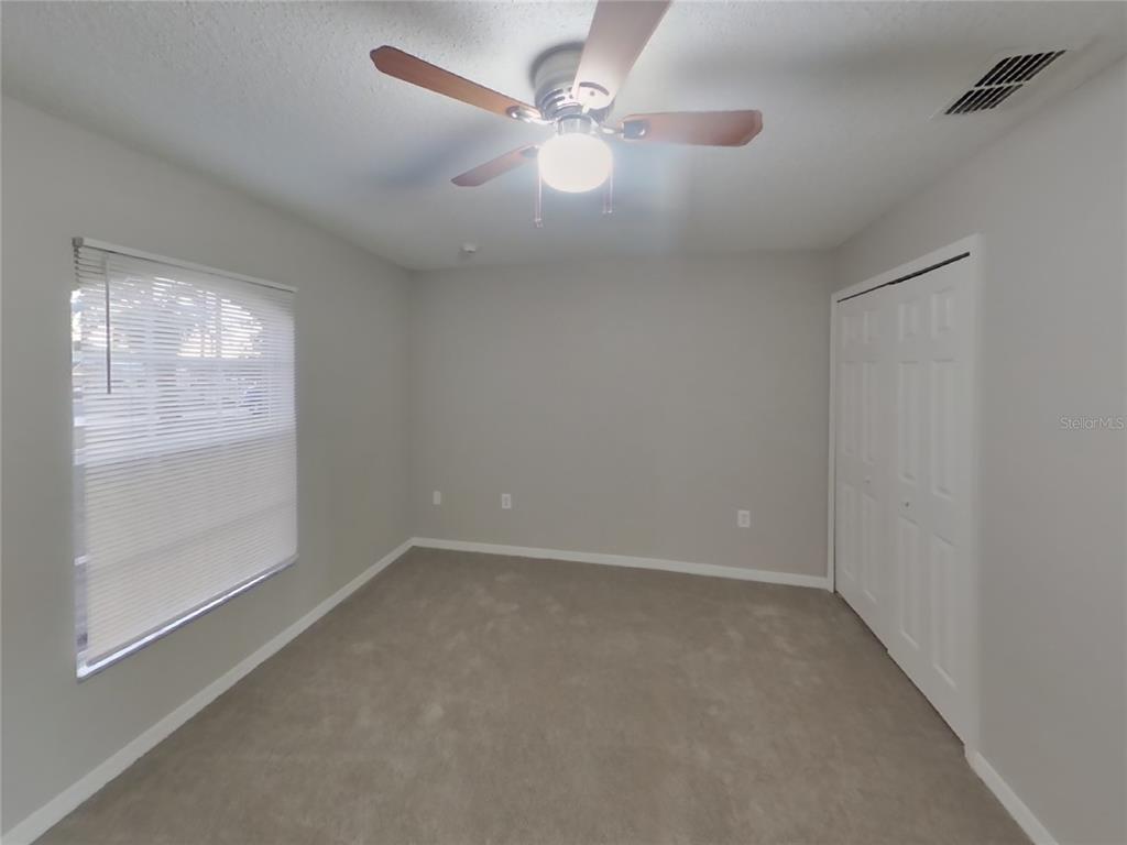 Undisclosed Address Spring Hill, FL 34609 - Photo 11 of 17 an empty room with windows and fan