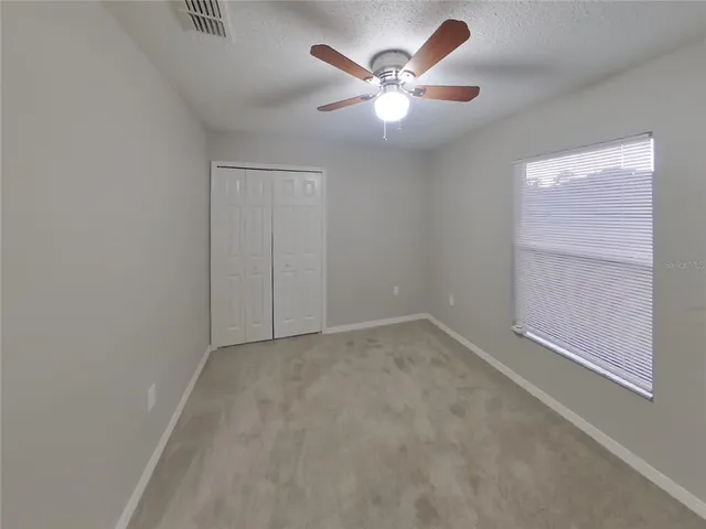 an empty room with a chandelier fan