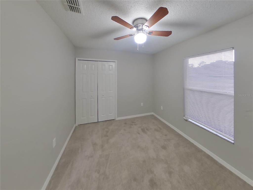 Undisclosed Address Spring Hill, FL 34609 - Photo 12 of 17 an empty room with a chandelier fan