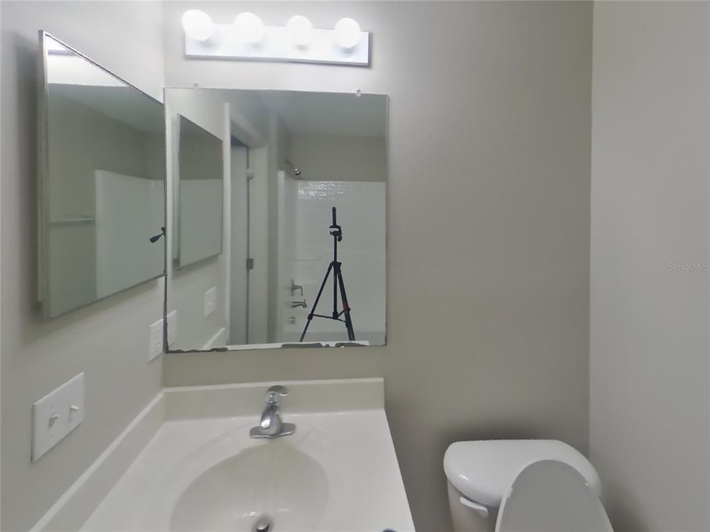 Undisclosed Address Spring Hill, FL 34609 - Photo 15 of 17 a bathroom with a toilet sink and mirror