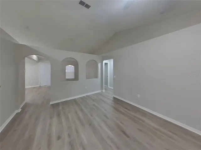an empty room with wooden floor and mirror