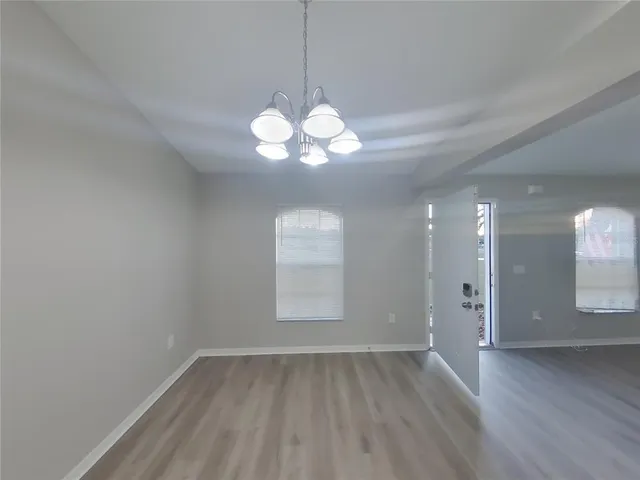 a view of a room with wooden floor and a window