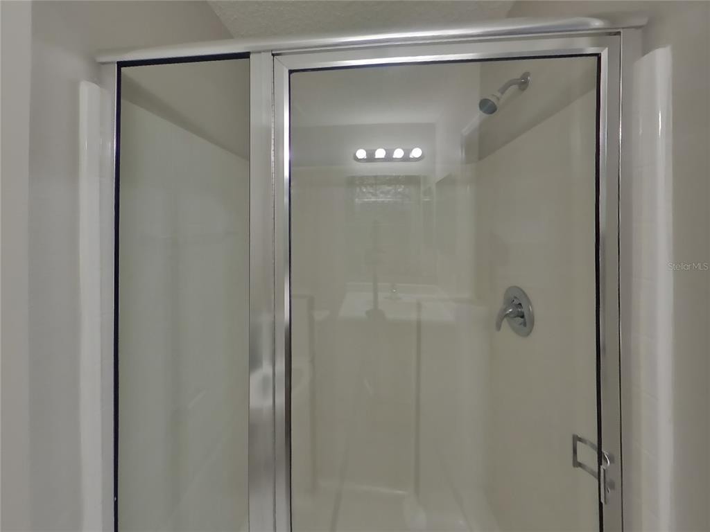 Undisclosed Address Spring Hill, FL 34609 - Photo 10 of 17 a bathroom with a glass shower door
