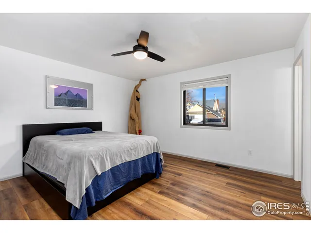 a bedroom with a bed and a painting on the wall
