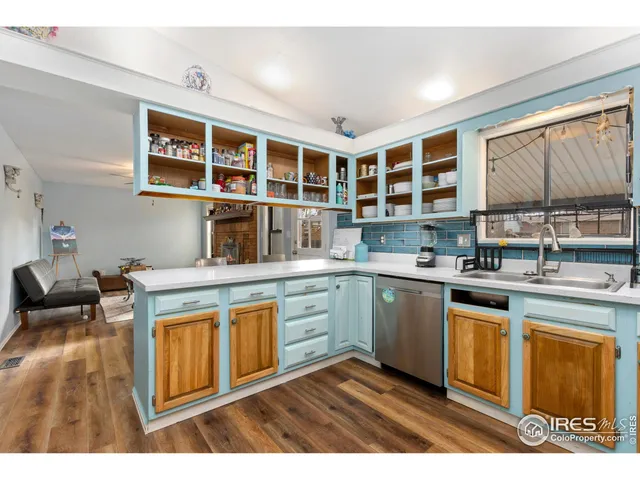 a kitchen with stainless steel appliances granite countertop a stove a sink dishwasher and cabinets with wooden floor
