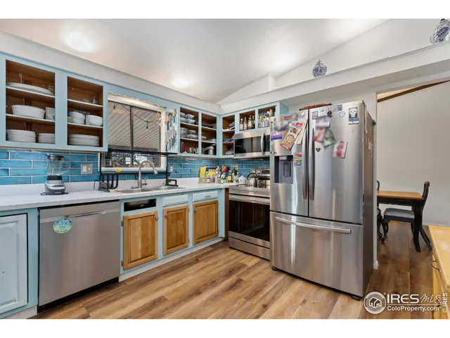 a kitchen with stainless steel appliances granite countertop a refrigerator a stove and a sink