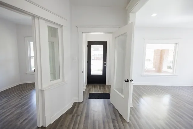 a view of a hallway with wooden floor and stairs