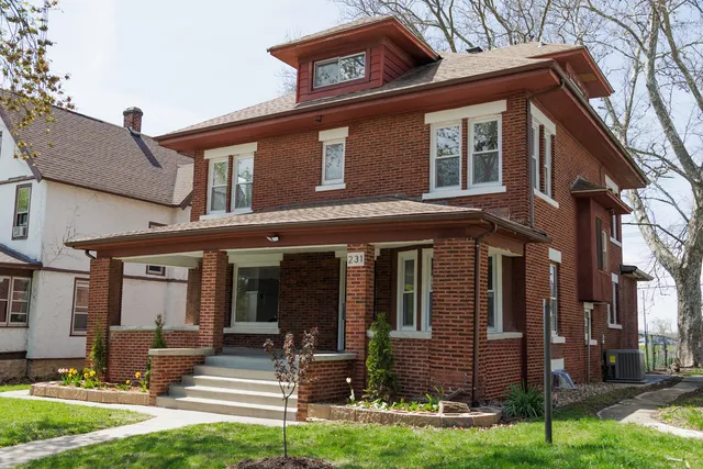 a front view of a house with garden and plants
