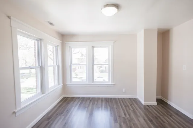 a view of an empty room with wooden floor