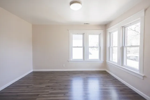 a very nice looking room with wooden floor and white walls