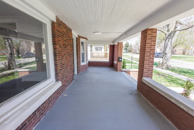 a view of hallway with wooden floor and windows