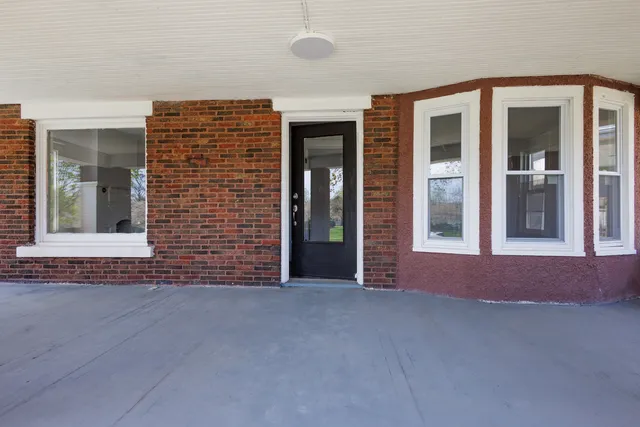 front view of a brick house with a large window