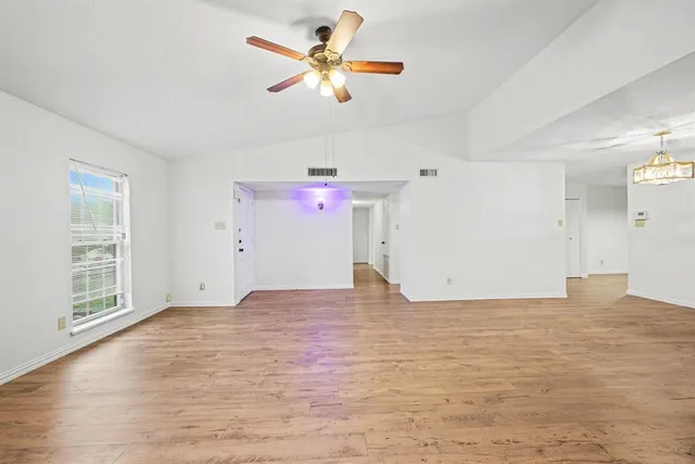 a view of empty room with wooden floor