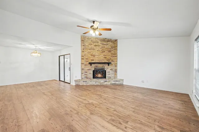 a view of empty room with fireplace and fan
