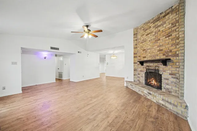 an empty room with windows and fireplace