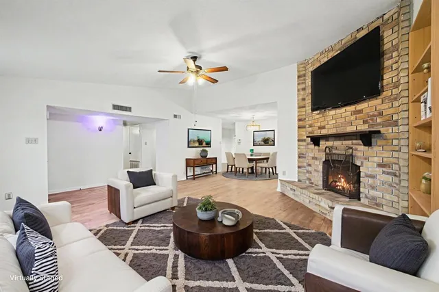 a living room with furniture a flat screen tv and a fireplace
