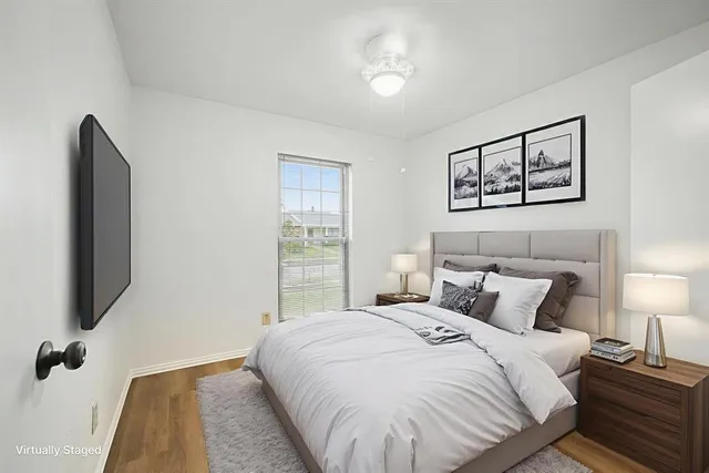 a bedroom with a bed and a flat tv screen on dresser
