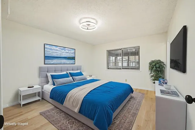 a bedroom with bed and a flat screen tv