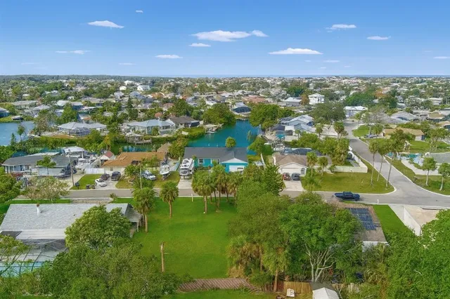 an aerial view of residential houses with outdoor space and trees