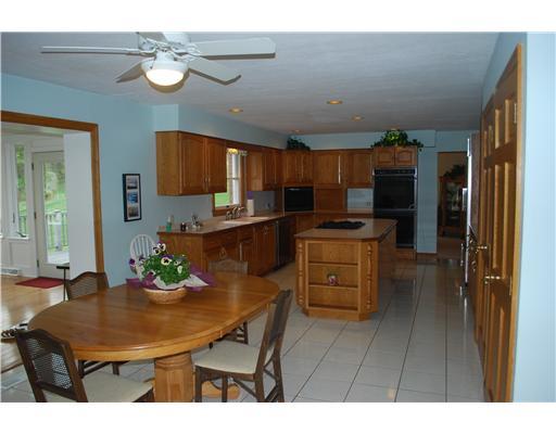 Kitchen. Large eat in kitchen with breakfast bar and wet bar.  Gas cook top is in island.  Refrigerator is subzero and has wood frontage like cabinets.  Floor is neutral ceremic tile.