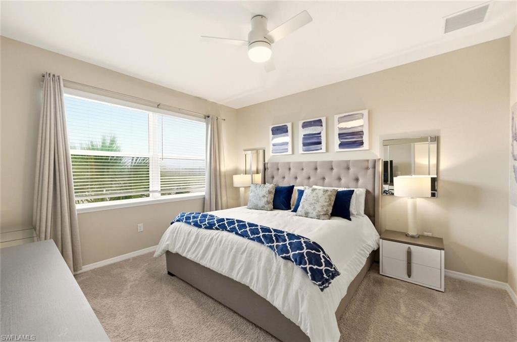 9365 Pocida Court, Unit 202 Naples, FL 34119 - Photo 18 of 40 a bedroom with a large bed and a chandelier