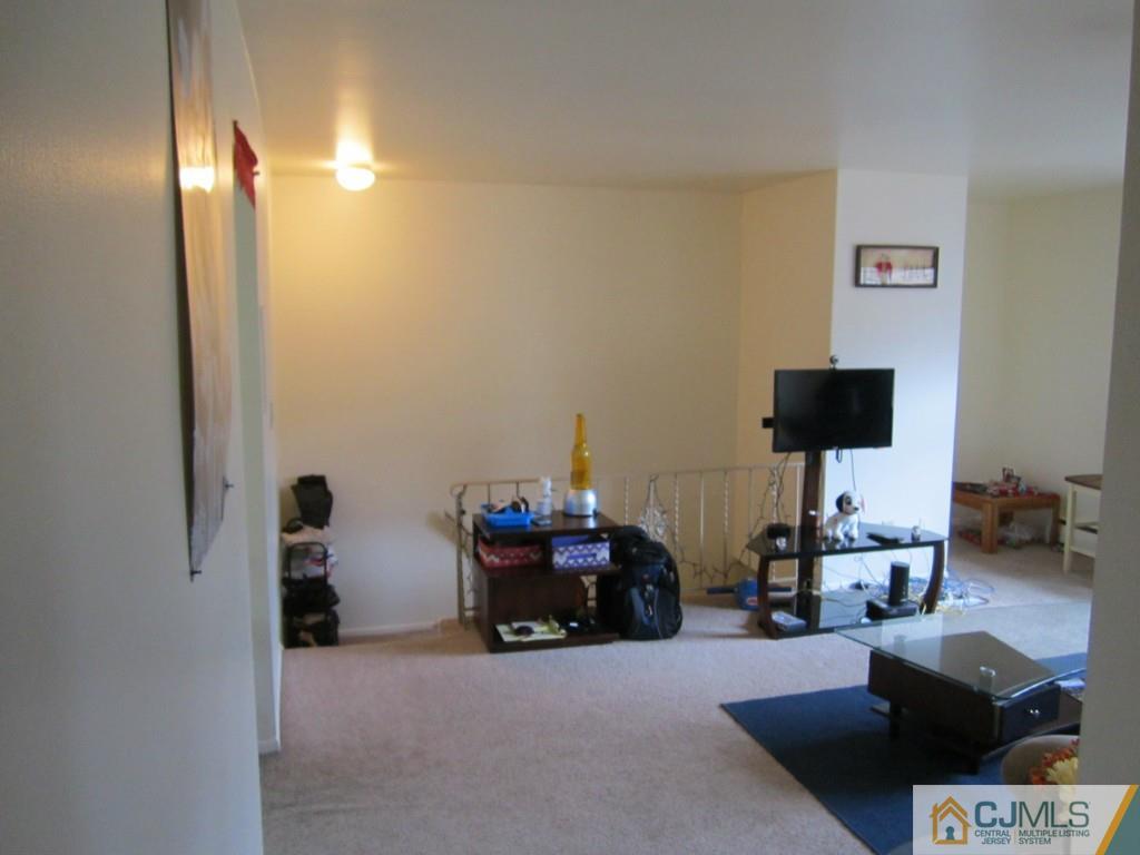 50 Fox Road, Unit 5B Edison, NJ 08817 - Photo 2 of 10 a living room with furniture a flat screen tv and a fireplace