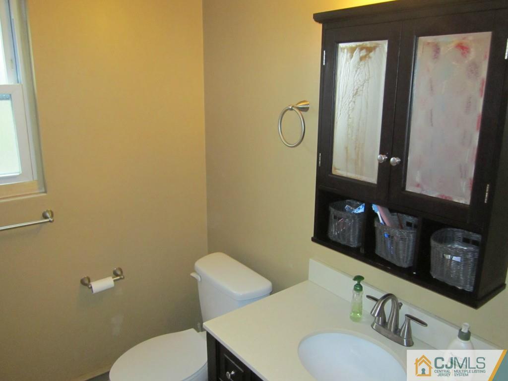 50 Fox Road, Unit 5B Edison, NJ 08817 - Photo 4 of 10 a bathroom with a granite countertop toilet sink and mirror