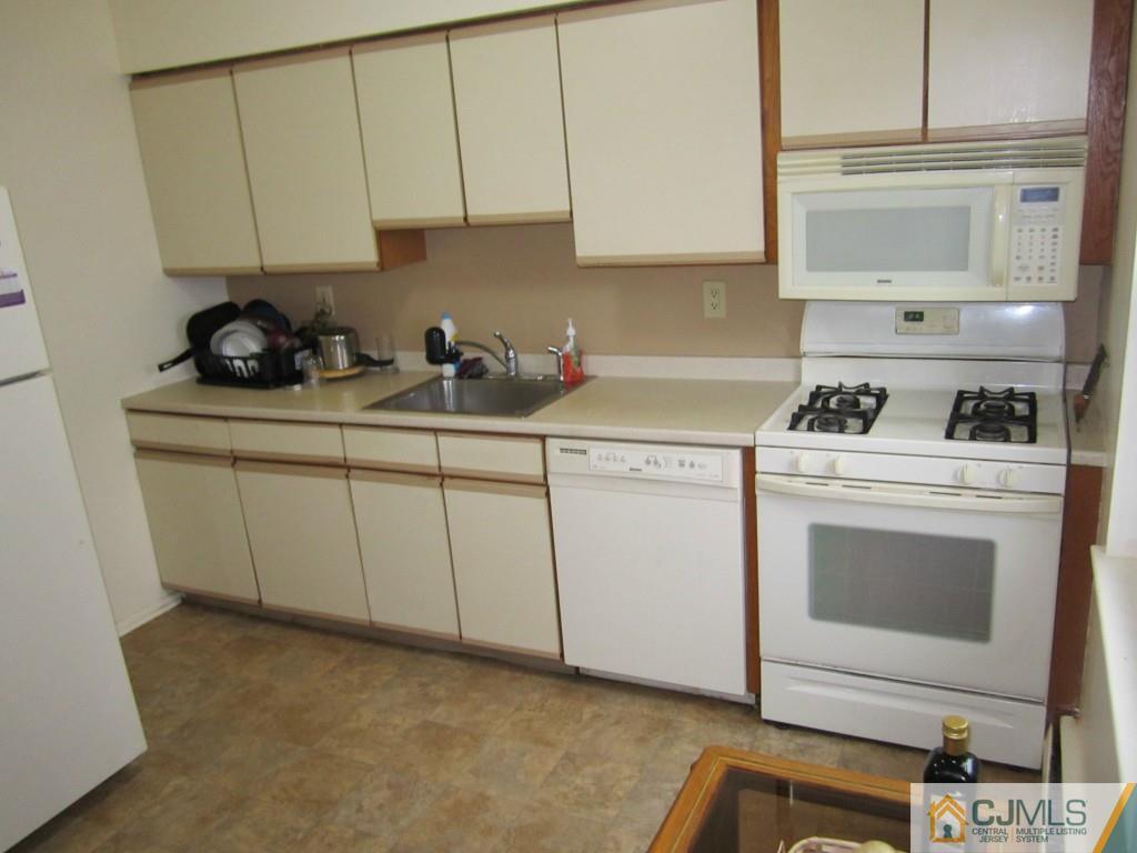 50 Fox Road, Unit 5B Edison, NJ 08817 - Photo 7 of 10 a kitchen with white cabinets sink and white appliances