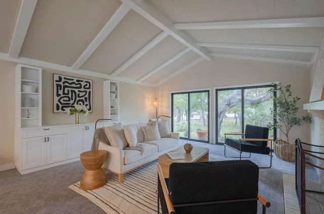 a living room with furniture fireplace and a large window