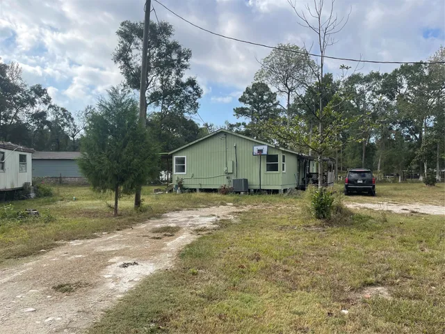 a view of a house with backyard and a tree