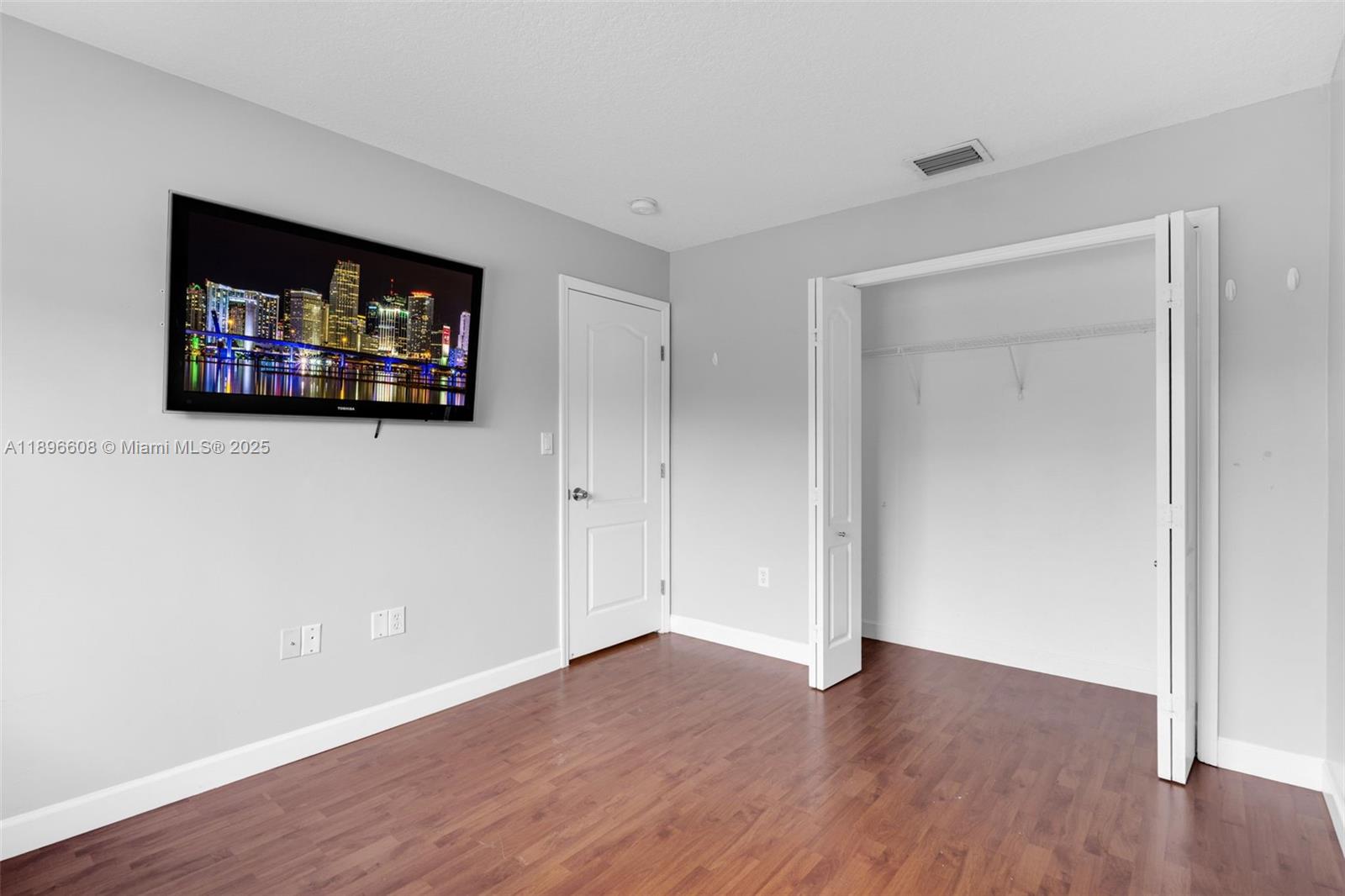 2883 Southwest 129th Terrace, Unit 2883 Miramar, FL 33027 - Photo 9 of 18 a view of an empty room with wooden floor