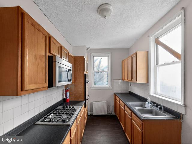 609 East 41st Street Baltimore, MD 21218 - Photo 5 of 9 a kitchen with a large window appliances and cabinets