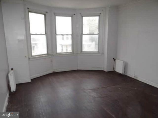 609 East 41st Street Baltimore, MD 21218 - Photo 6 of 9 an empty room with wooden floor and windows