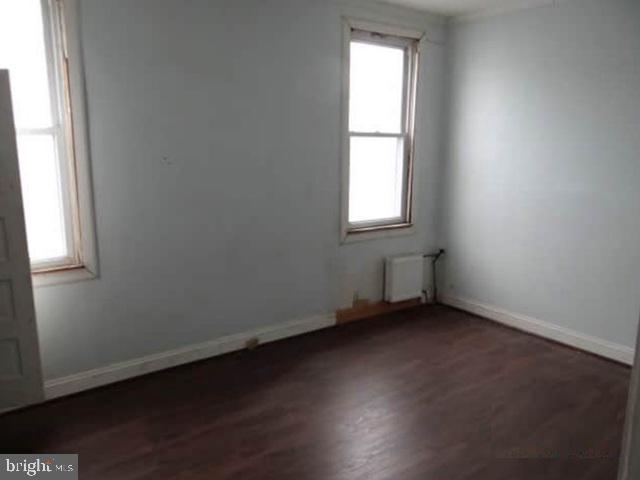 609 East 41st Street Baltimore, MD 21218 - Photo 7 of 9 an empty room with wooden floor and windows