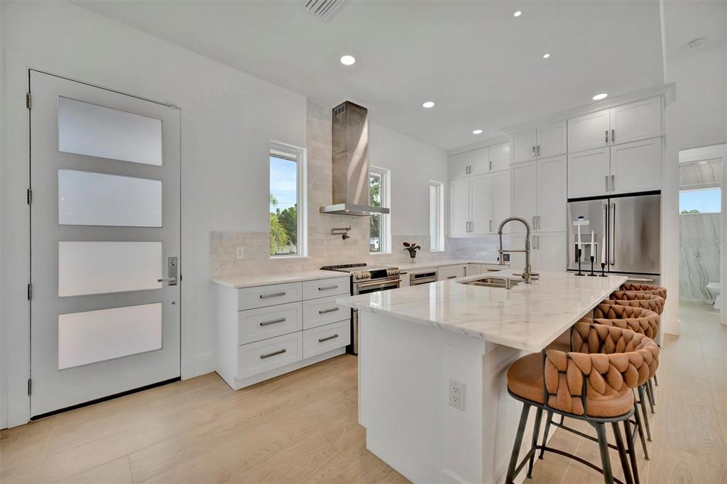 916 Highland Street Sarasota, FL 34234 - Photo 13 of 48 a large kitchen with kitchen island a stove a sink a dining table and chairs