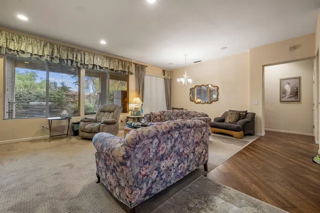 a living room with furniture floor to ceiling window and wooden floor