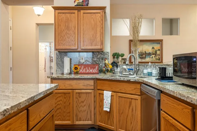 a kitchen with stainless steel appliances granite countertop a sink stove and cabinets