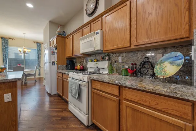 a kitchen with granite countertop a sink a stove and cabinets