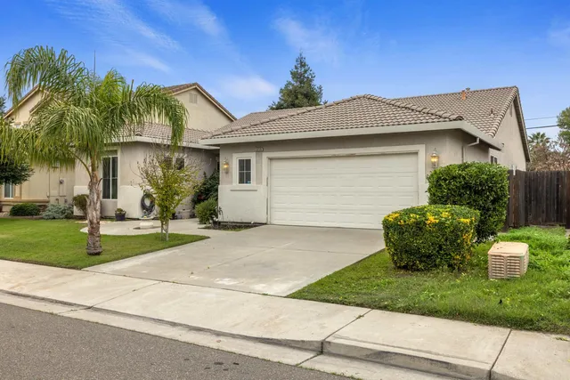 a front view of a house with a garden and plants