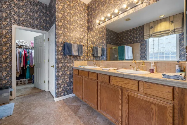 a spacious bathroom with a double vanity sink and a mirror