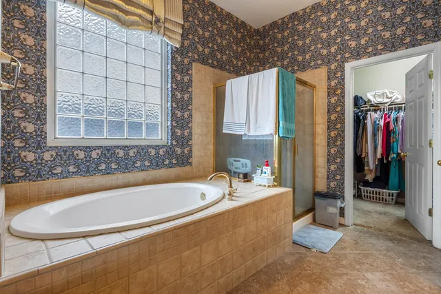 a white bath tub sitting in a bathroom next to a window