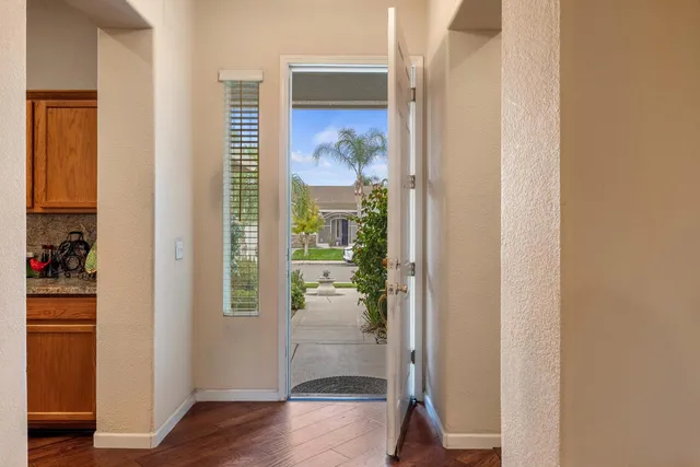 a view of a hallway with wooden floor and windows